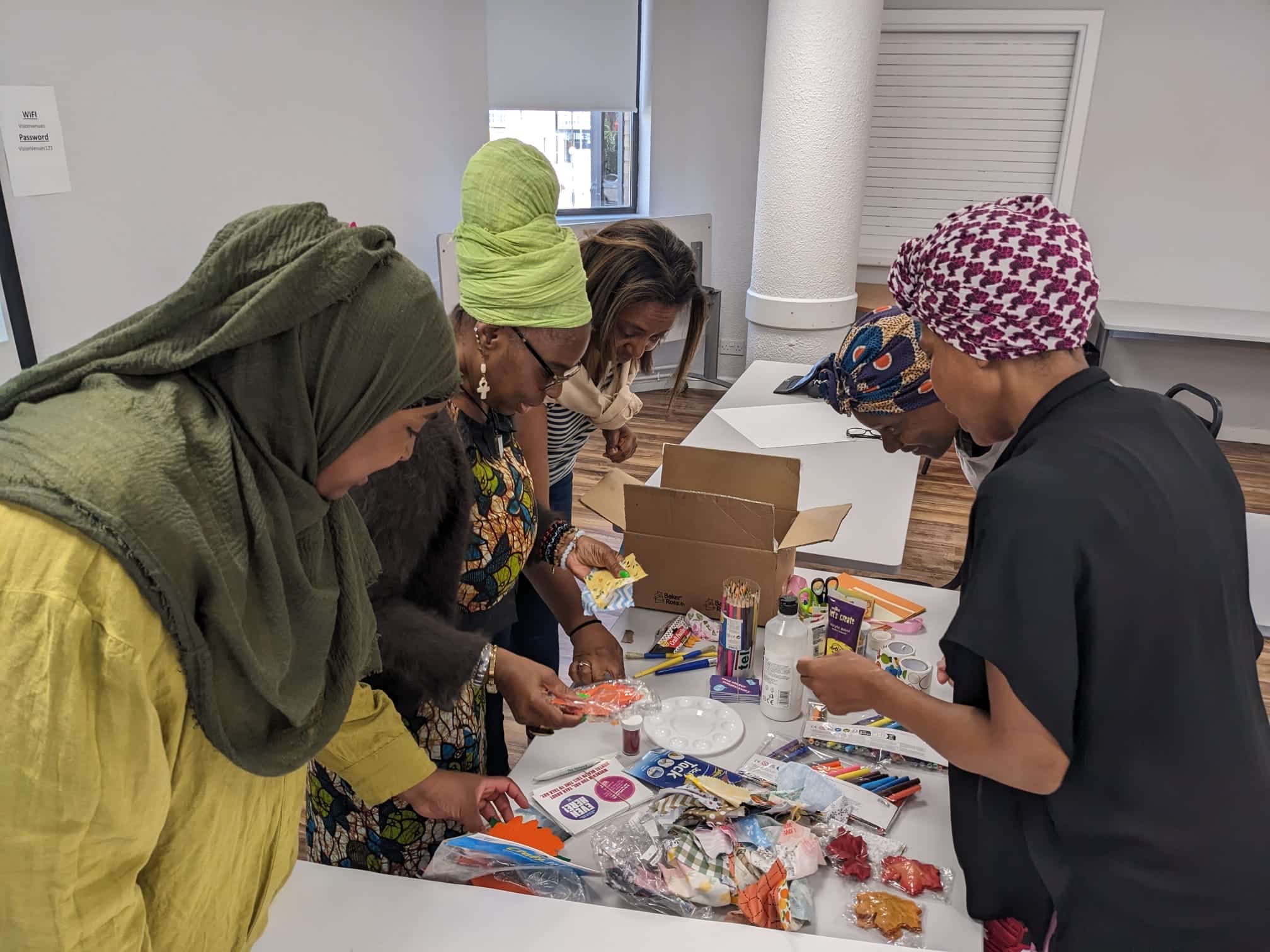 a group of black women from Redbridge sorting through art supplies